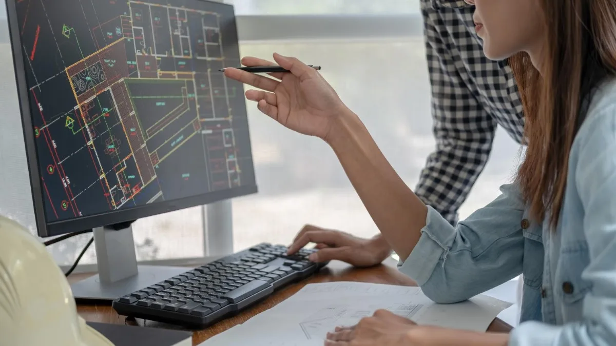 Étudiante sur ordinateur analysant une maquette BIM en management économique de la construction