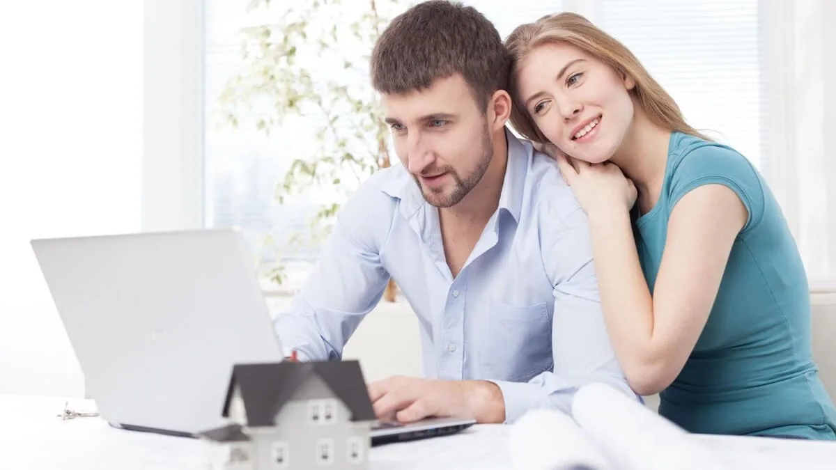 Couple assis à une table avec ordinateur pour préparer un projet immobilier à Saint-Malo