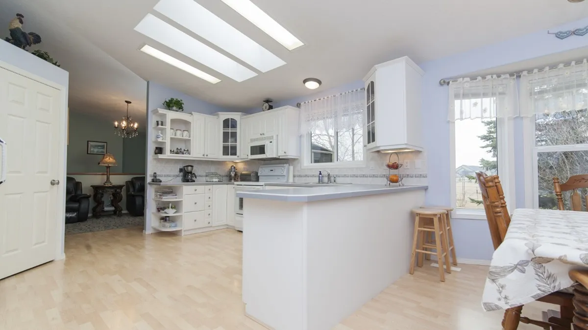 Cuisine ouverte avec îlot central donnant sur une salle à manger lumineuse